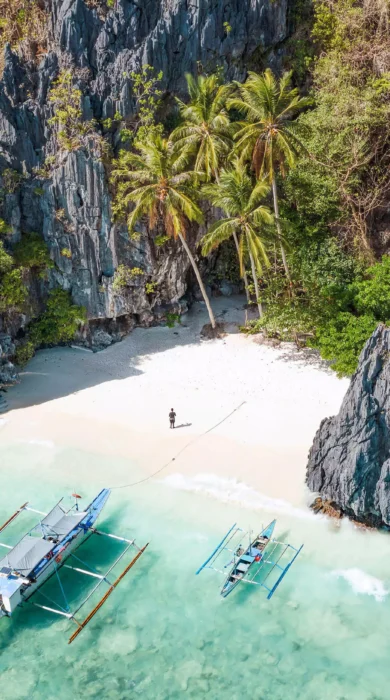 View from above of sandy beach and rock formations with clear water in Philiipines